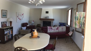 Ein Essbereich mit einem runden Tisch, Stühlen, einer Vase und einem Kamin.
