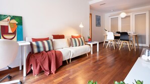 Una sala de estar moderna con un sofá, una mesa de comedor y sillas.