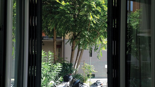 A window view of a building with a parked motorcycle and a tree in the foreground. - HAPPY HOME BOLOGNA Cozy, quiet, Close to CITY CENTER and EXHIBITION, AC, WiFi (Bologna)