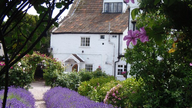 A white building with a tiled roof and a small window.