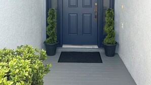 A dark blue front door with a small window above it, flanked by two potted plants. - Lakeview Villa in Kissimmee, pool & hot tub, free pool heat, close to Disney (Kissimmee)