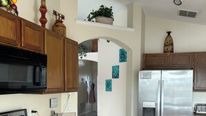 A kitchen with wooden cabinets, a stainless steel refrigerator, a microwave, and an oven. - Lakeview Villa in Kissimmee, pool & hot tub, free pool heat, close to Disney (Kissimmee)