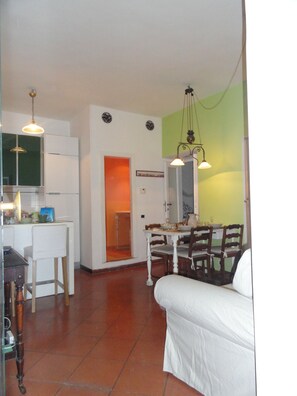 A compact living space with a dining area, kitchenette, and a small seating area.