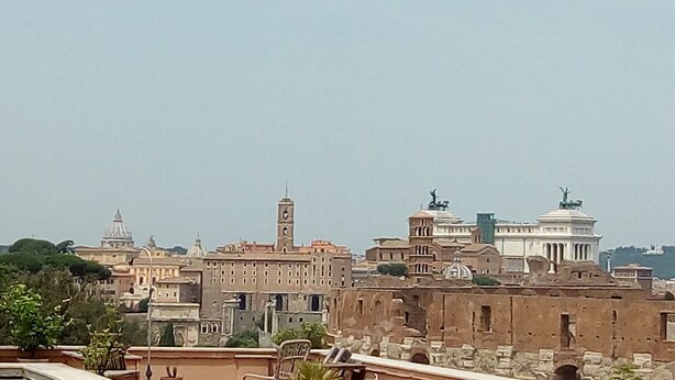 Paisagem urbana com arquitetura histórica, incluindo uma torre imponente e edifícios com cúpulas.