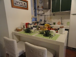 A small kitchen with a dining area, equipped with basic appliances and utensils.
