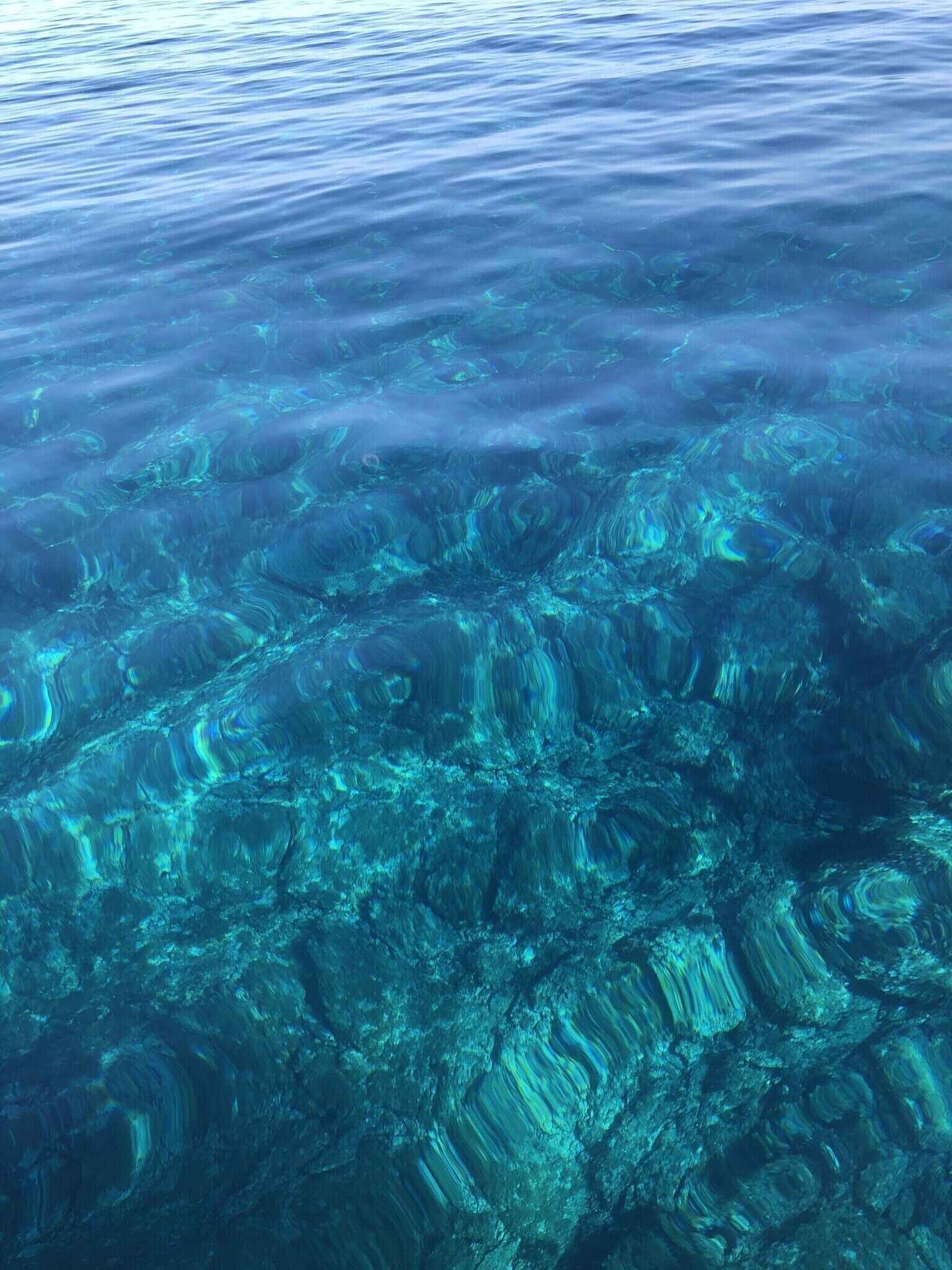 Vista clara de una masa de agua con formaciones visibles bajo el agua.