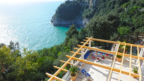 A terrace with a view of the sea and cliffs, wooden pergola, outdoor seating, and potted plants. - Il canto delle sirene,  in the heart of Amalfi Coast, parking Property overview (Conca dei Marini)