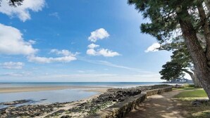 Ein Küstenpfad mit Steinmauer, einer Rasenfläche und Blick auf das Meer.
