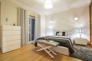 Une chambre à coucher moderne avec un lit, des tables de chevet, un banc et une commode.