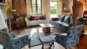 A rustic living room with stone walls, wooden beams, a fireplace, and a staircase. - Charming, Detached Farmhouse With Private Swimming Pool. (Lizant)
