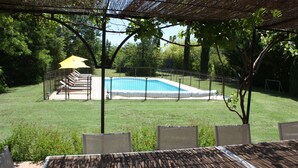 A backyard with a pool, a covered seating area, and a lawn. - La Villa Rose is a spacious villa in Provence with a large pool. (Le Thoronet)