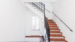 A staircase with a black metal railing and red steps, leading to a white door with a window. - Count Checco. A heaven in the rooftops of Rome few steps away from the pantheon (Roma)