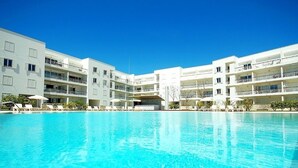 A modern hotel with a large pool, multiple balconies, and a clear blue sky. - Lovely Townhouse on Lagos Marina with swimming pool, Air Con & WiFi (LAGOS, Algarve)