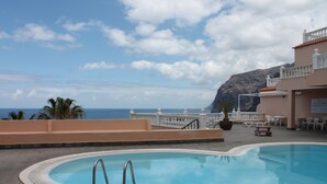 A swimming pool with a view of the ocean and mountains in the background. - Superb apartment with stunning sea and cliff views, 2 terraces and free wifi. (Santiago del Teide)