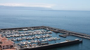A marina with numerous boats docked at a pier. - Superb apartment with stunning sea and cliff views, 2 terraces and free wifi. (Santiago del Teide)