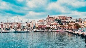 A marina with boats, a bus, and a cityscape with buildings in the background. - Villa With Private Pool & Garden, 5 minutes walk to the Beach (Eivissa)