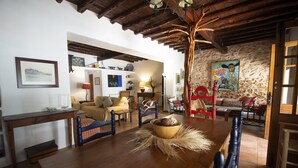 A rustic dining area with a wooden table, chairs, and a stone wall. - Villa With Private Pool & Garden, 5 minutes walk to the Beach (Eivissa)