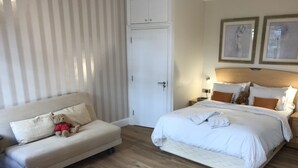 Una camera d'albergo con un letto, un divano, un tavolino e un armadio.