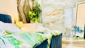 Een moderne slaapkamer met een groot bed, een marmeren wand en een potplant.