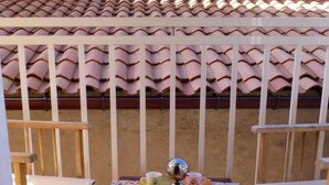 A small outdoor patio with a table set for two, surrounded by a white railing. - Large charming duplex, air-conditioned and WiFi in the heart of the citadel  (Bonifacio)