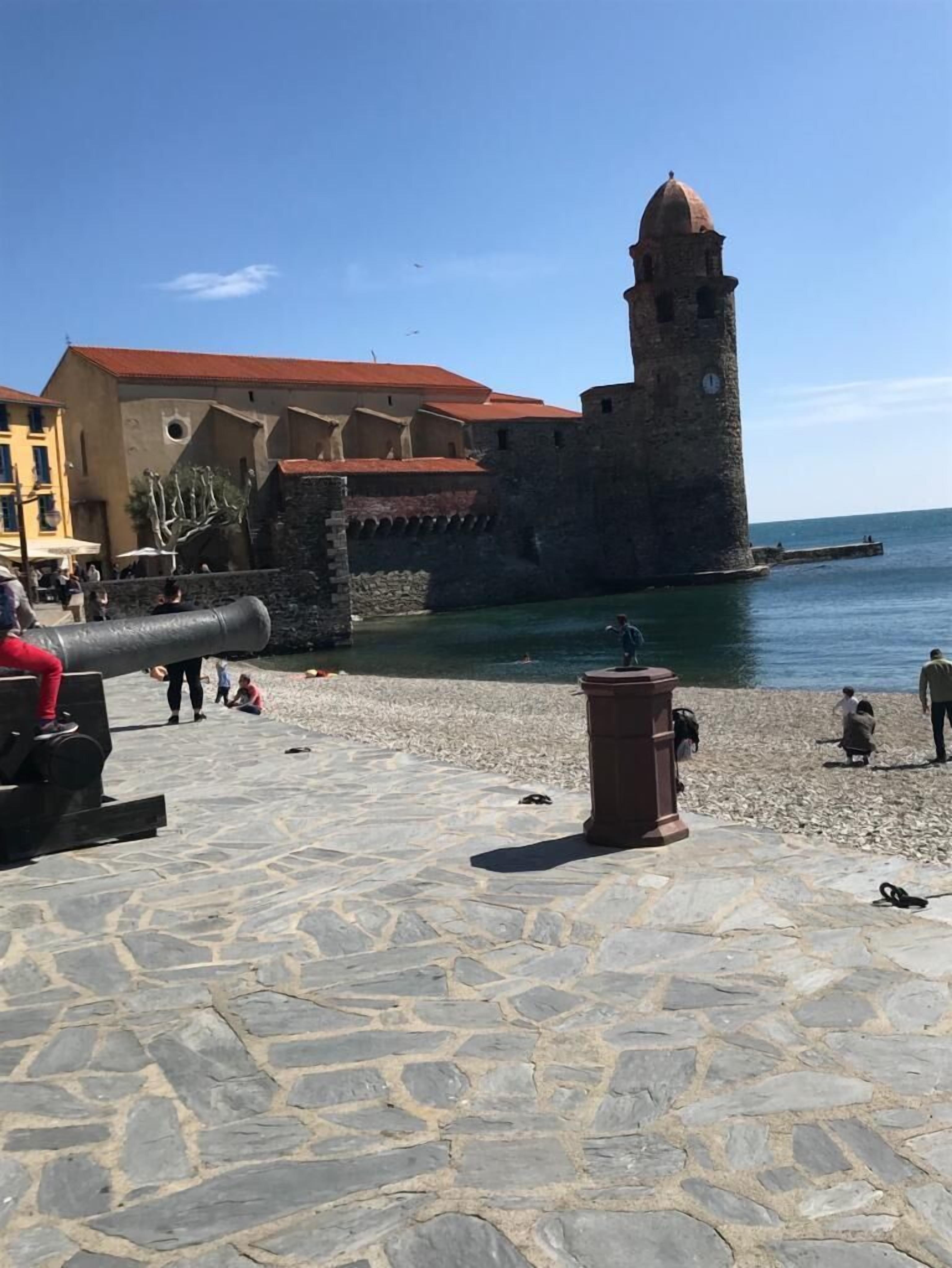 Un fort historique doté d’une tour imposante, d’un canon et d’une promenade pavée de pierres le long de la mer.
