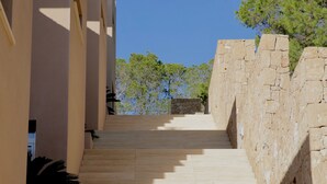 Una escalera que conduce a un edificio, con un cielo azul despejado arriba.