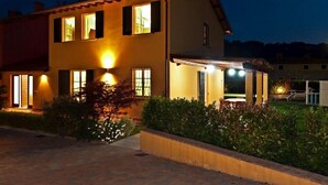 A two-story house with multiple windows, a well-lit entrance, and a landscaped garden. -  Very beautiful Villa / Private Swimming Pool / PrivateGarden / Jacuzzi (Lucca)