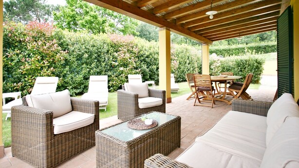 An outdoor patio with wicker furniture, a glass-top table, and a covered area with a wooden ceiling. -  Very beautiful Villa / Private Swimming Pool / PrivateGarden / Jacuzzi (Lucca)