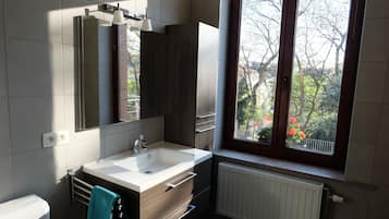 Uma casa de banho moderna com uma janela ampla, uma pia e um porta-toalhas.