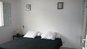 A bedroom with a bed, two bedside tables, and a window. - Apartment/ flat - Sartène (Sartène)
