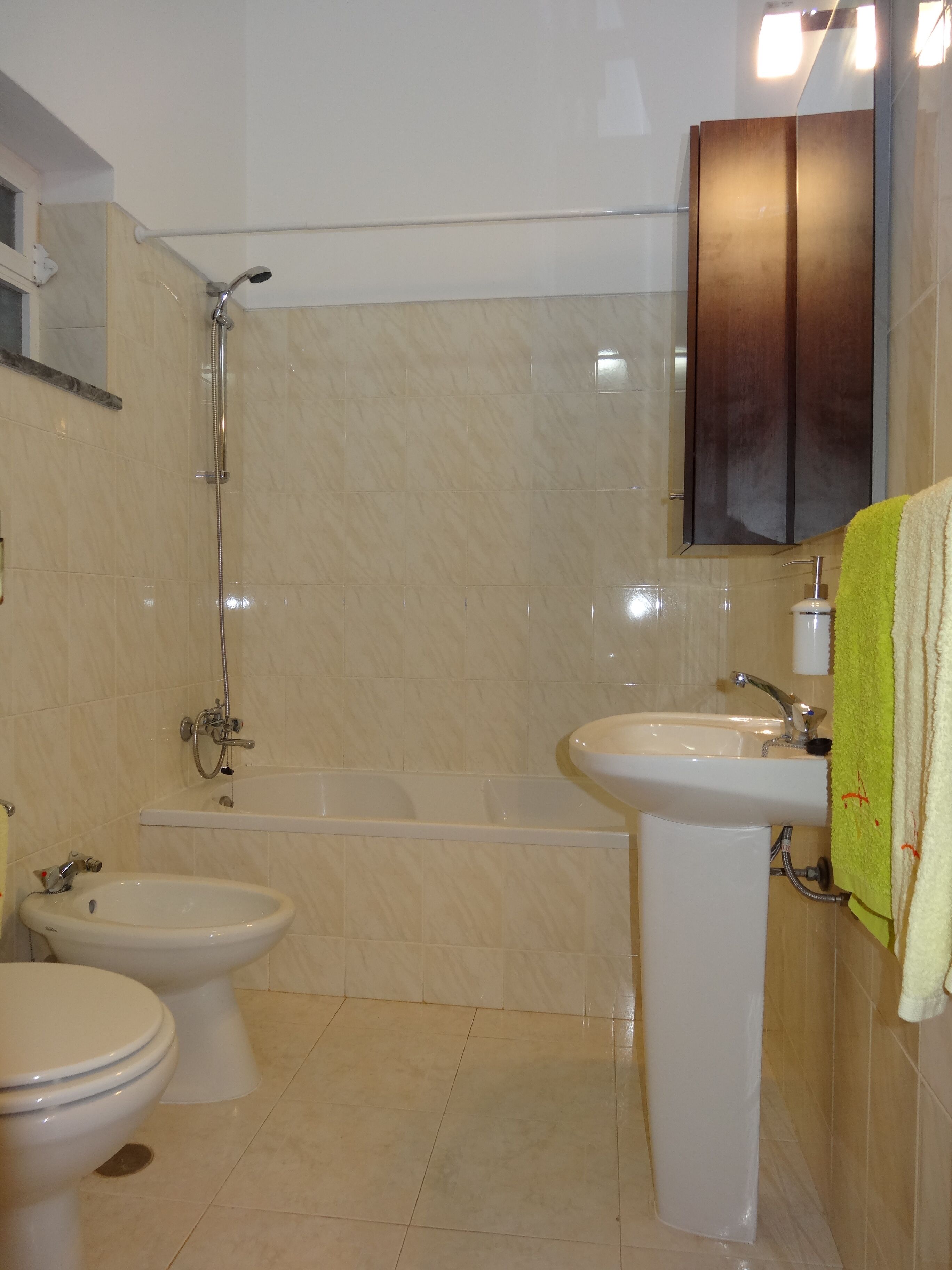 A bathroom with a bathtub, a sink, a toilet, and a bidet.