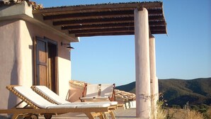 A pool area with lounge chairs and a pergola.
