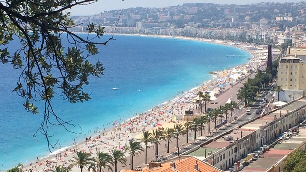 A coastal cityscape with a beach, palm trees, and buildings along the shore. - Air-conditioned villa, sea view and only 500m walk to sandy beach and San Peire! (Roquebrune-sur-Argens)
