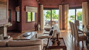 A spacious living room with a fireplace, comfortable seating, and a view of the outdoors.