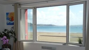 A room with a large window overlooking a beach. - LE BIGORNEAU IMPRENABLE VIEW of the MORGAT CROZON BEACH (Crozon)