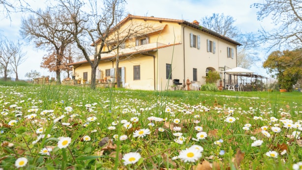 Una casa de dos pisos con jardín delantero.