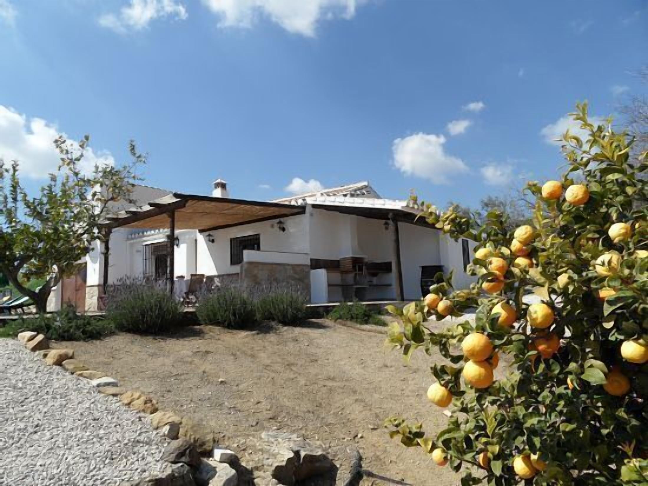 A white building with a sloped roof and a covered patio area.