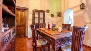 Un coin repas avec une table en bois, des chaises et un buffet.