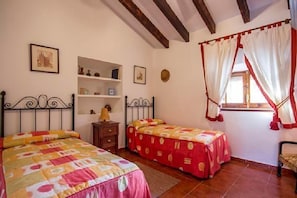 A bedroom with two beds, a wooden dresser, and a window with curtains. - Casa El Trigal for 4 people (Antequera)
