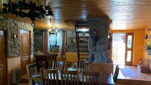 A cozy room with a stone wall, wooden ceiling, and a dining table with chairs. - Tipical Country Side house whith nice landscapes and pool (Fafe)