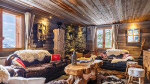 Un acogedor interior de cabaña de madera con un sofá de cuero, muebles de madera rústica y una pared de piedra.