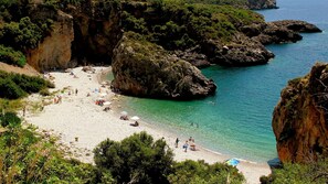 Una playa con acantilados rocosos y agua turquesa cristalina.