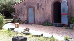 Un edificio rústico con un sendero de ladrillo que lleva a una puerta de madera.