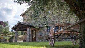 Ein Steinhaus mit einem hölzernen Wagen davor.