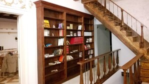 A staircase with wooden balusters and a wooden bookcase filled with books and decorative items.