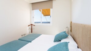 A bedroom with a bed, a window with a view, a ceiling fan, and a bedside table. - Total Relax Apartment (Porís de Abona ( Arico ))