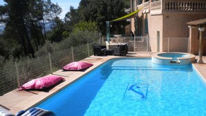 Una piscina con un símbolo de delfín, almohadas rosadas y una silla hinchable azul.
