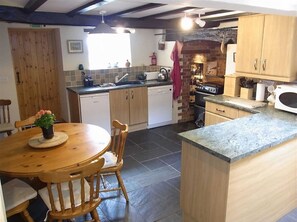 Enjoy cooking in this well-equipped kitchen with a central island, stove, and dining area.