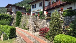 A hillside hotel with stone walls, balconies, and lush greenery. - Two-room apartment in Residence with swimming pool and panoramic lake view in Sale Marasino (Sale Marasino)