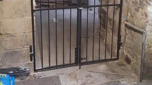 A metal gate with a window, a concrete floor, and a stone wall. - Family House with garden in Lake District National Park - sleeps 8 (Bootle)